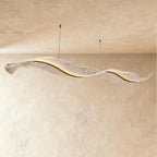 A wide view of the Clérachic wave chandelier shows its rippling acrylic form against a plaster wall.