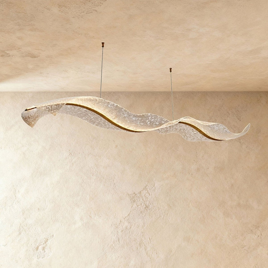 This Clérachic wave-form chandelier curves gently, its rippled acrylic panels lit against plaster tones.
