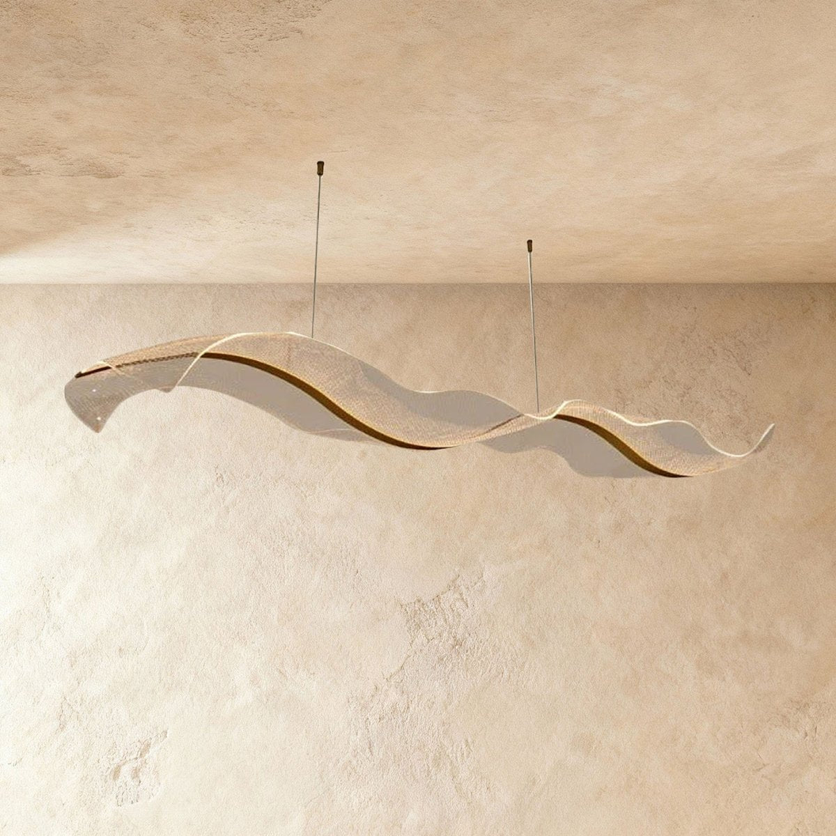 This Clérachic sculptural chandelier curves in a long double wave against a warm plaster backdrop.