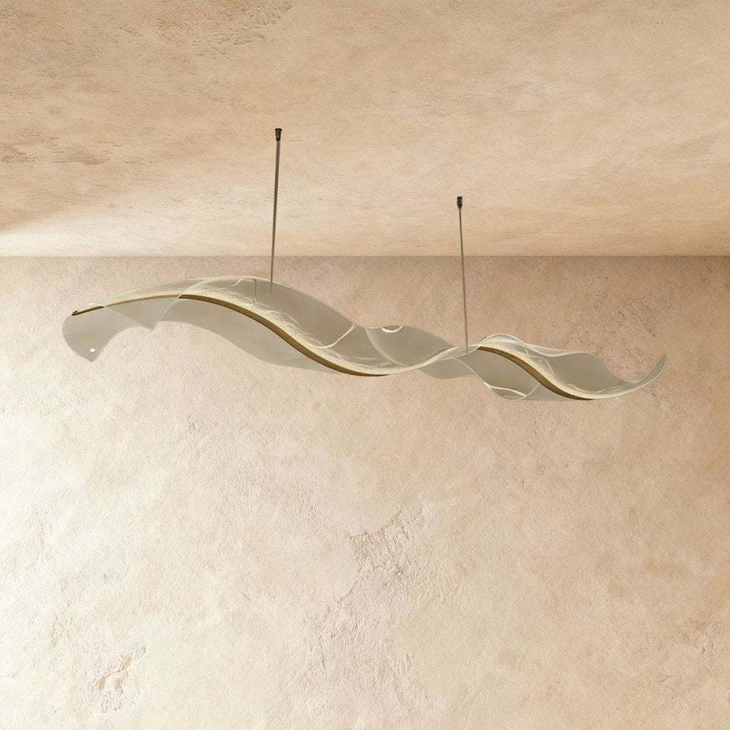 Clérachic's ribbon chandelier glows along a glassy frosted surface in its long double-wave shape.
