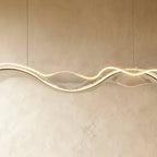 Close-up of the lit Clérachic chandelier shows a dimpled, water-ripple texture along its LED edge.