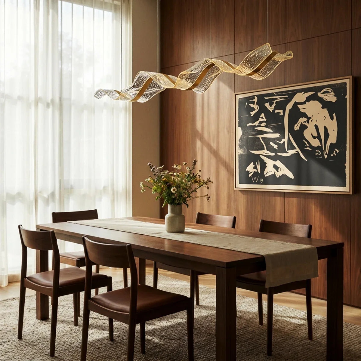 A lit Clérachic wave chandelier curves above a walnut dining table beneath a bold graphic artwork.