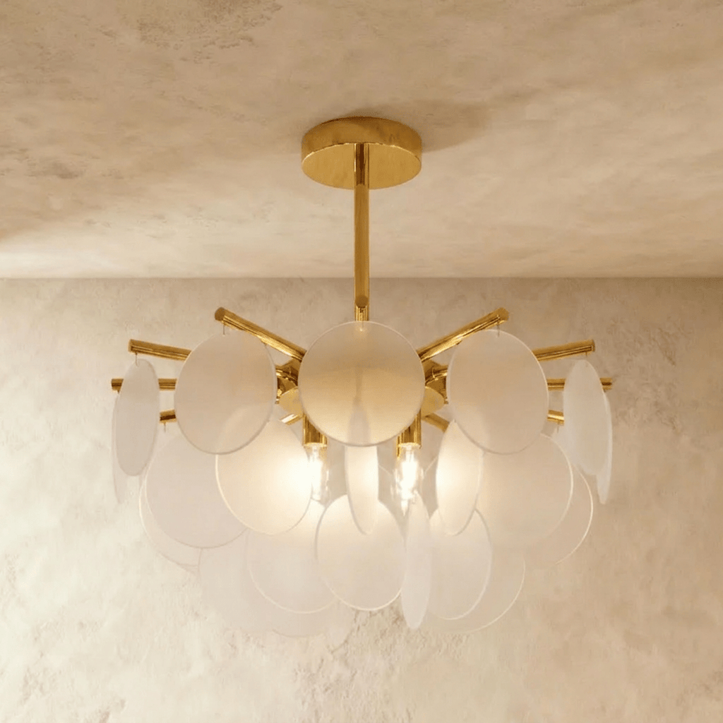 Clérachic Isla chandelier lit warm, frosted translucent glass petals clustered densely around a brass ceiling stem.