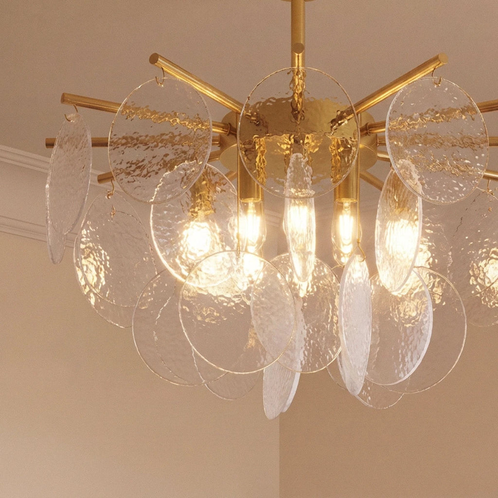 Clérachic Isla chandelier detail, hammered clear glass discs catching light around the brass frame and bulbs.