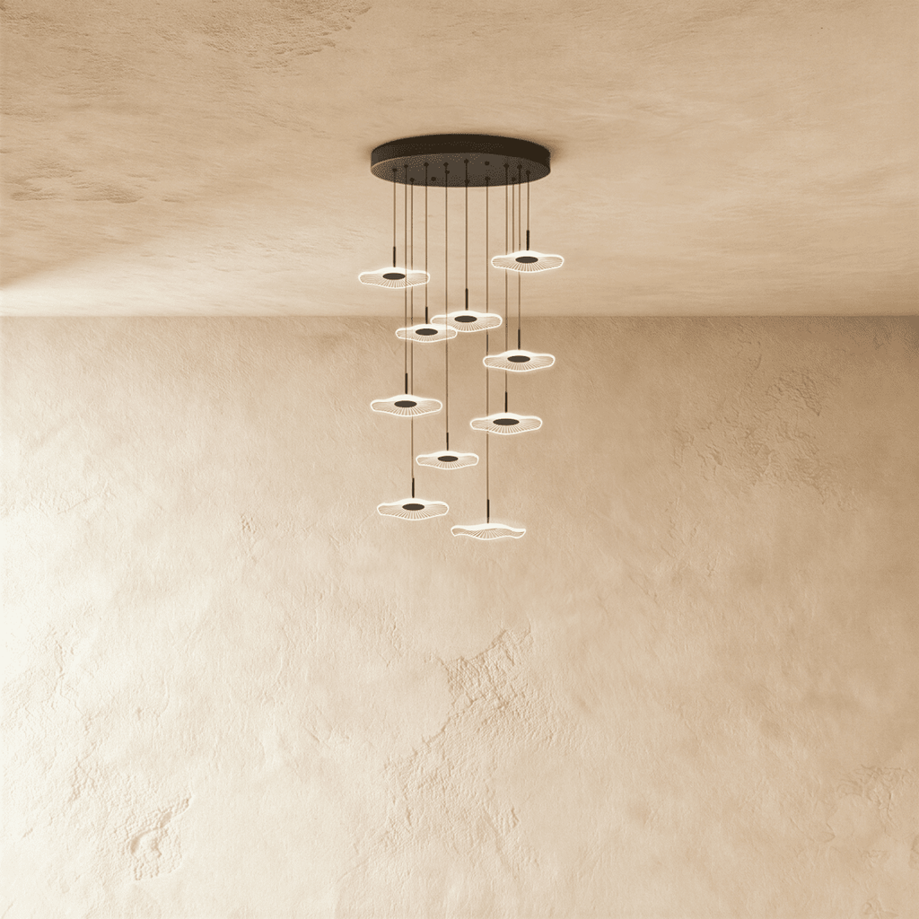 Clérachic staircase chandelier in black, a tall spiral of glowing flower-shaped discs cascading from the ceiling.