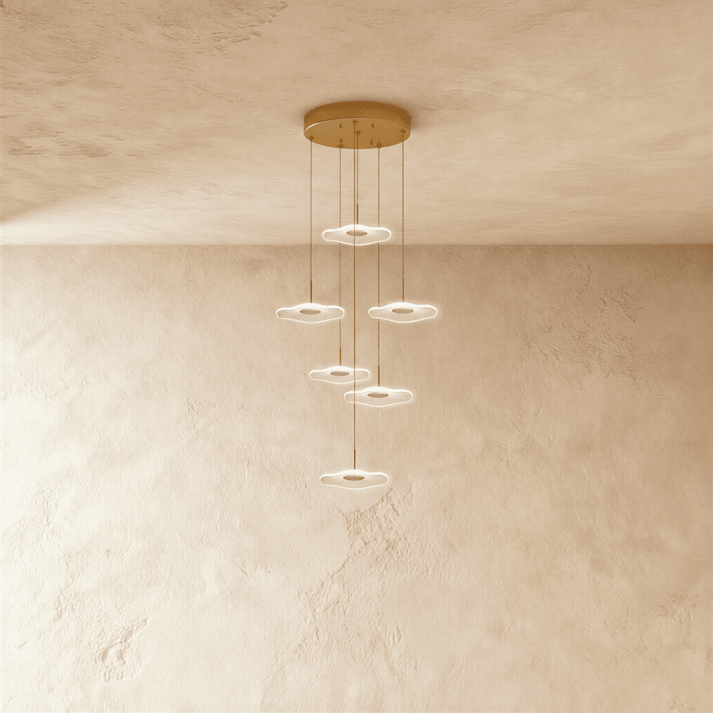 Clérachic staircase chandelier in gold, six glowing flower-shaped discs spiralling down at staggered heights.