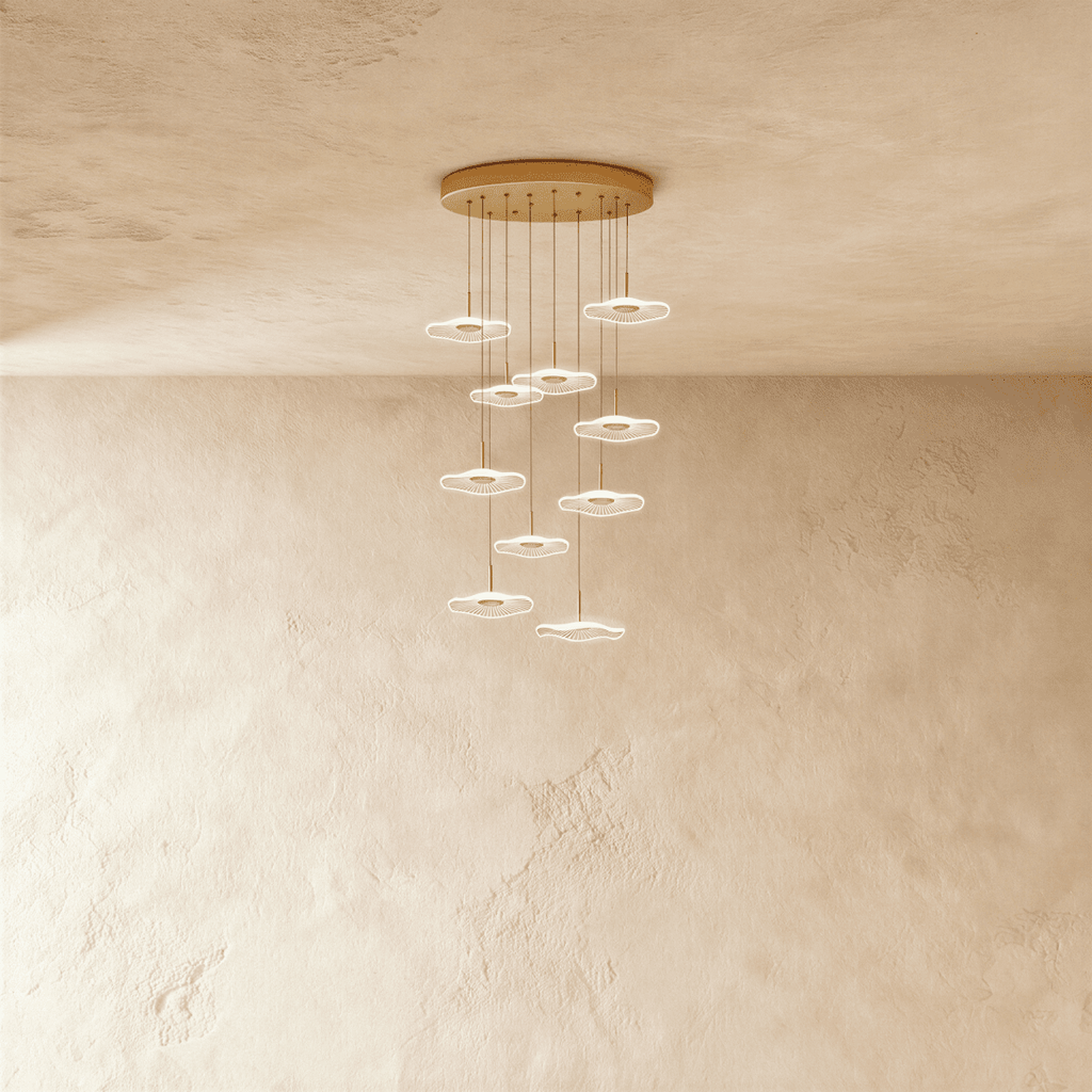 Clérachic staircase chandelier in gold, a tall spiral of glowing flower-shaped discs cascading from the ceiling.