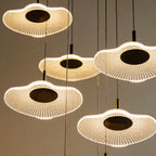 Close-up of the Clérachic staircase chandelier's ribbed flower-shaped discs, each glowing warm white at its centre.