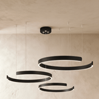 Clérachic's three-ring LED chandelier hangs in matte black, its round rings stacked at staggered heights.
