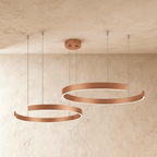 This Clérachic two-ring chandelier hangs in a rose gold finish, its two round rings staggered in height.