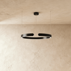 A single Clérachic LED ring chandelier hangs in matte black, its round profile glowing evenly from below.