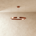 A single Clérachic LED ring chandelier hangs in a rose gold finish, glowing evenly around its round profile.