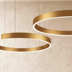 A close view of the Clérachic ring chandelier's warm gold finish shows two stacked rings glowing softly.