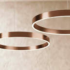A close view of the Clérachic ring chandelier's rose gold finish shows two stacked rings glowing softly.