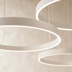 A close view of the Clérachic ring chandelier's pale finish shows its stacked rings glowing from below.