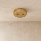 The Clérachic ring chandelier's warm gold ceiling canopy holds two suspension cables for its stacked rings.