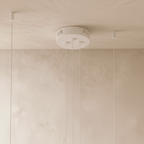 The Clérachic three-ring chandelier's matte white canopy holds three cables with vents for the LED driver.