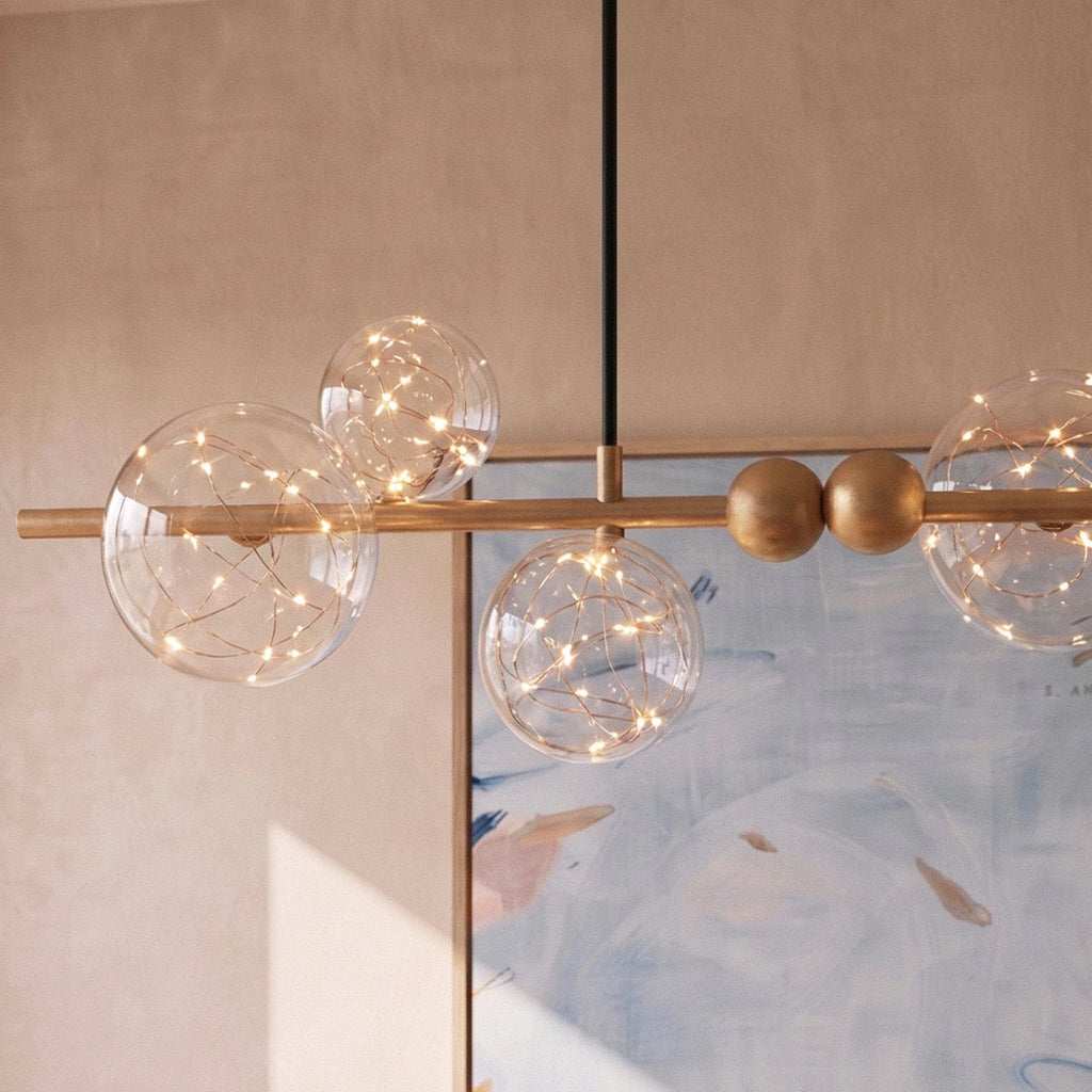 Close-up of the Clérachic chandelier's glass bubble globes, each lit with fine warm-white filament wire.