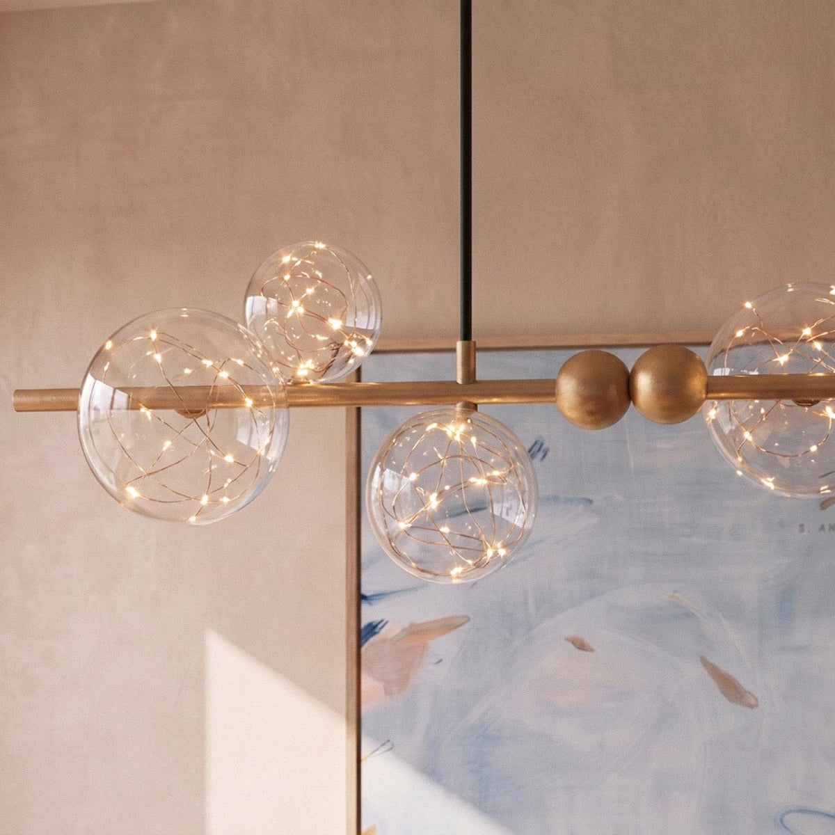 Close-up of the Clérachic chandelier's glass bubble globes, each lit with fine warm-white filament wire.