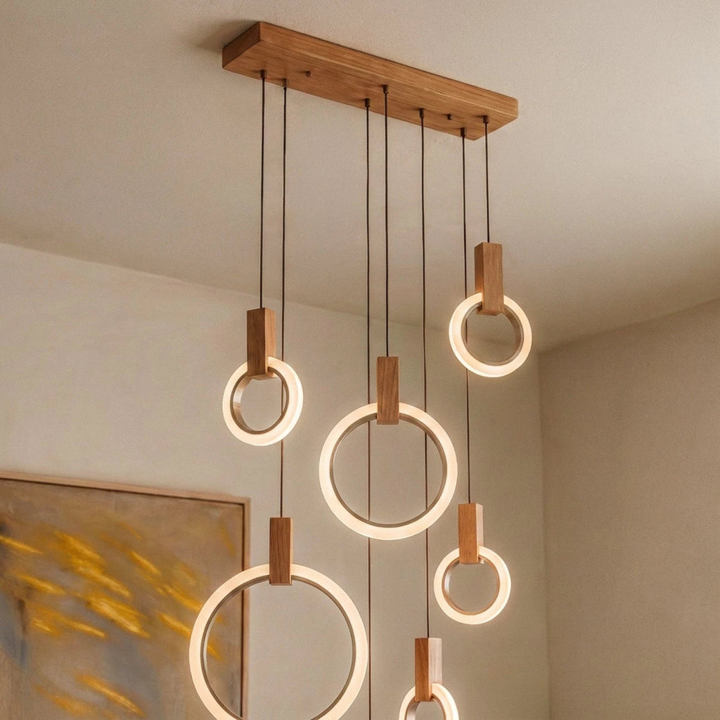 Clérachic close view of lit acrylic rings with oak blocks hanging at different heights from a long wooden canopy.
