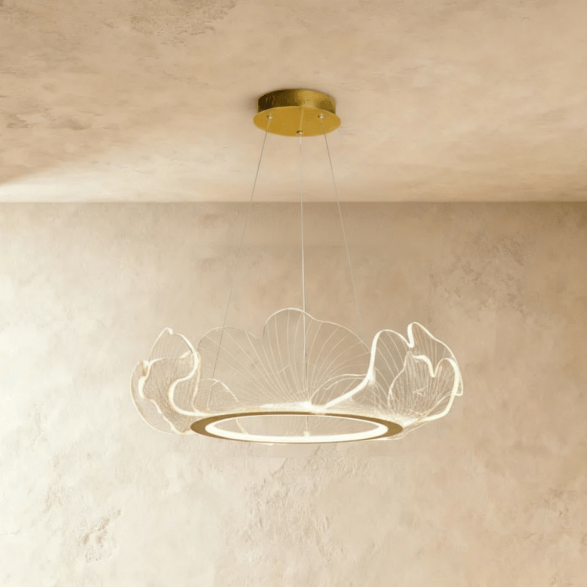 Clérachic gold-finished chandelier with a ring of clear acrylic leaf shades, hung from a round canopy against limewash.