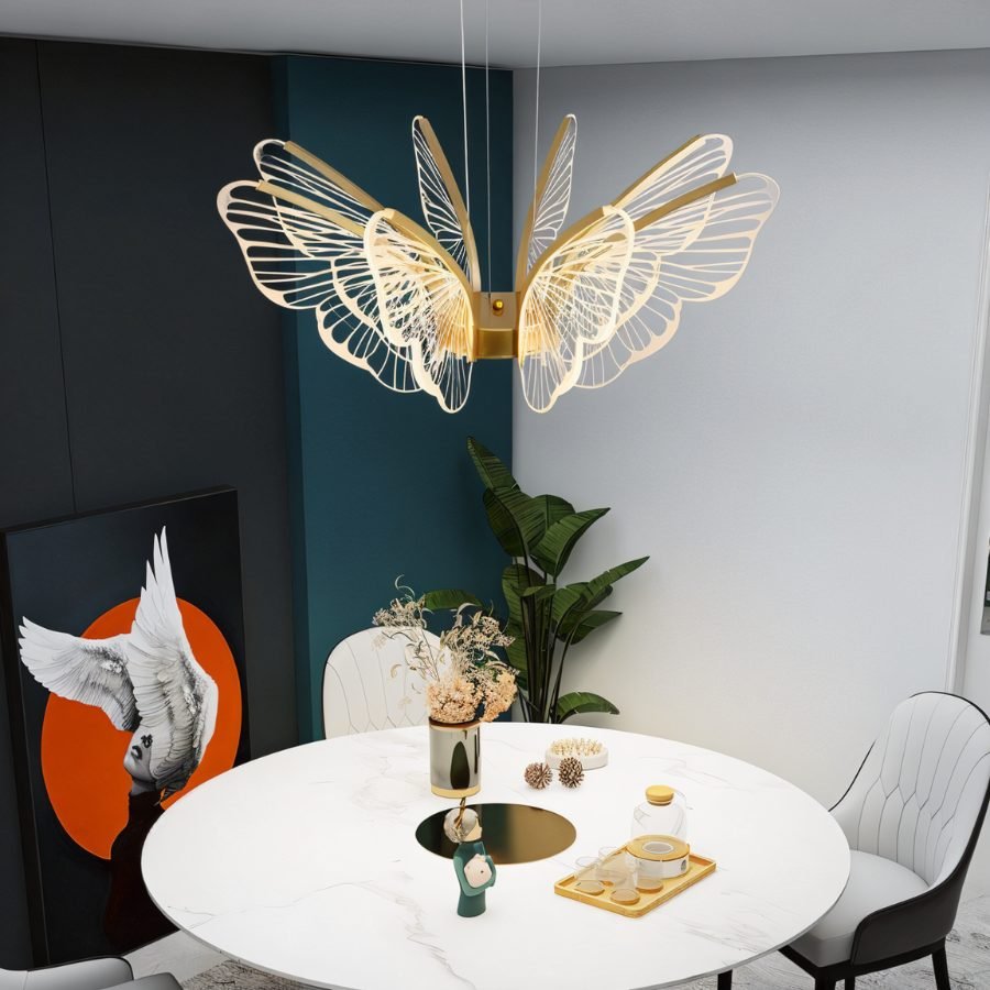 Clérachic butterfly chandelier with clear acrylic wings and gold arms above a round marble table in a teal and grey room.