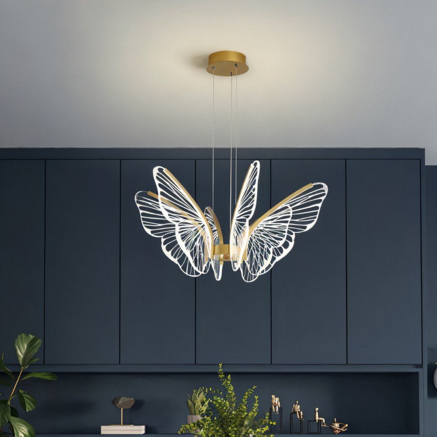 Clérachic butterfly chandelier with veined acrylic wings, hung on three cables in front of navy-grey cabinetry.