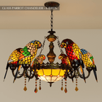 Clérachic chandelier of six glass parrots on dark arms, a pale amber glass bowl and amber crystal drops, on a chain.