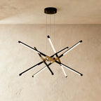 Clérachic ten-rod starburst chandelier in black and gold, slim LED rods crossing at varied angles from a central hub.