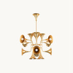 Gold trumpet-shaped heads branching from a central stem on this Clérachic chandelier, shown on a plain off-white backdrop.