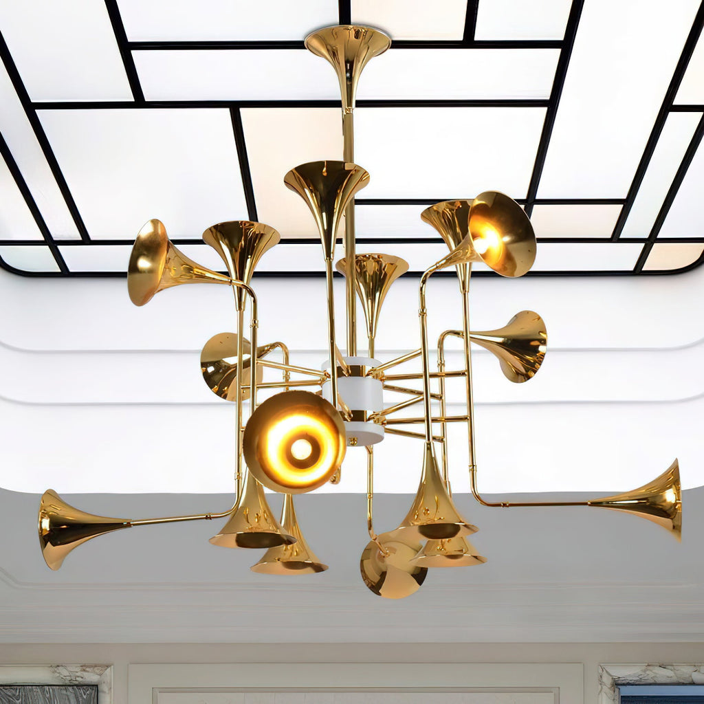 Looking up at the gold horn-shaped heads of this Clérachic chandelier, set against a ceiling of white panels and black lines.