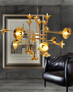 Gold trumpet-head Clérachic chandelier in a grey concrete-walled room, beside a framed print and a black leather armchair.