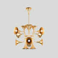 Smaller gold trumpet-head Clérachic chandelier on a plain light grey backdrop, hanging from a straight stem.