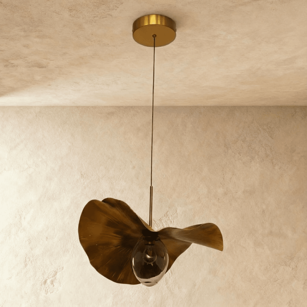 Clérachic pendant with a rippled gold-finish metal shade and a clear glass bulb, switched off, on a thin cord from a brass canopy.