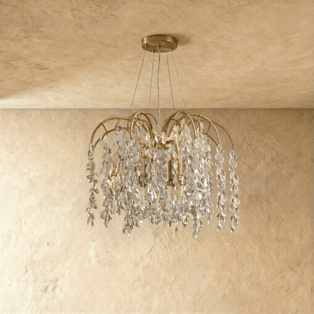 Clérachic gold chandelier with cascading crystal drops switched off, showing the clear teardrops and brass-toned arms in the studio
