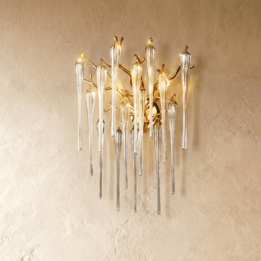 Clérachic gold branch wall lamp with clear fluted glass drops, shown a little larger on a plaster wall in warm light.