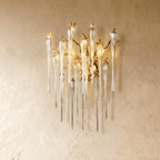 Clérachic gold branch wall lamp with clear fluted glass drops, shown a little larger on a plaster wall in warm light.