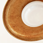 Detail of the brushed, mottled gold finish inside the dish of this Clérachic ceiling light, with the white diffuser at the edge.