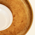 Close view of the hand-brushed gold dish interior and the rim of the white glass diffuser on this Clérachic light.