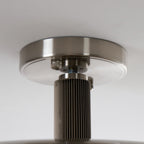 Detail of the round nickel canopy and ribbed stem on this Clérachic ceiling light, above the edge of the dish.