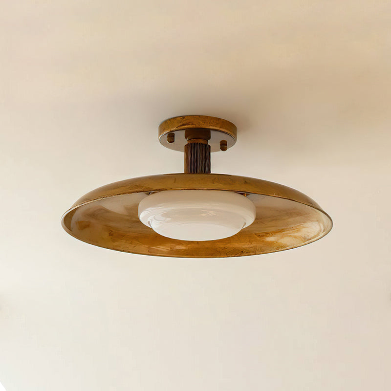 A Clérachic gold ceiling light from below, with the mottled dish, short stem and white diffuser against a pale ceiling.