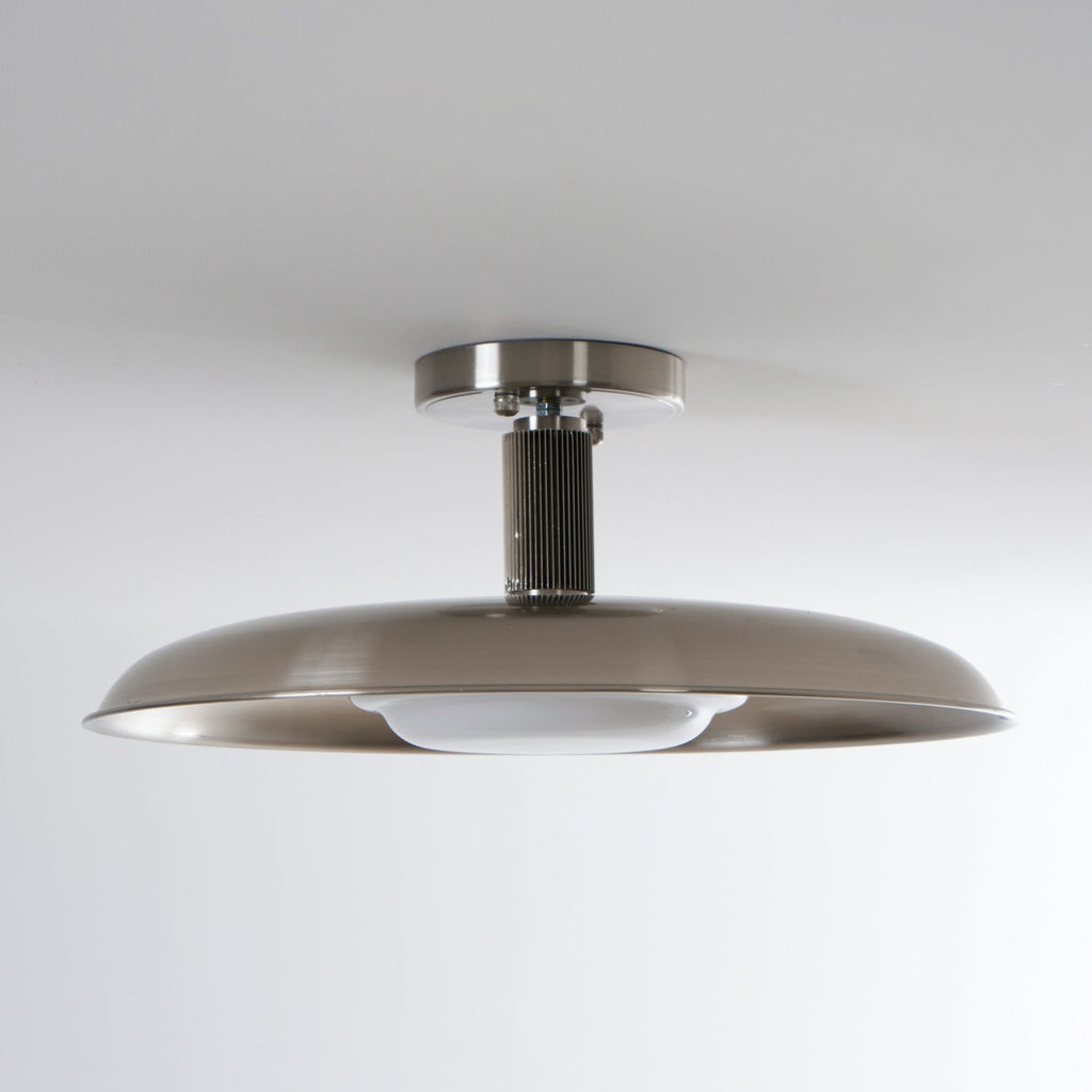Low view of this Clérachic nickel ceiling light, unlit, with a ribbed stem and the white diffuser tucked under the dish.
