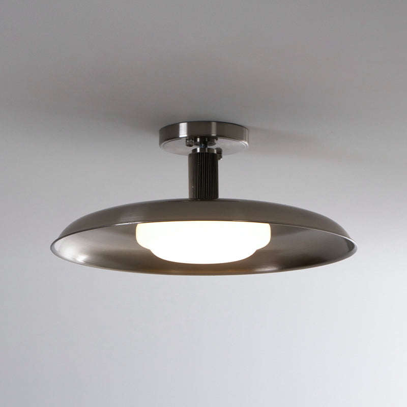 Front view of this Clérachic nickel ceiling light with a lit round diffuser beneath its brushed dish.