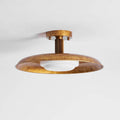 Gold Clérachic dish ceiling light with a mottled brass finish and a white diffuser, against a pale ceiling.