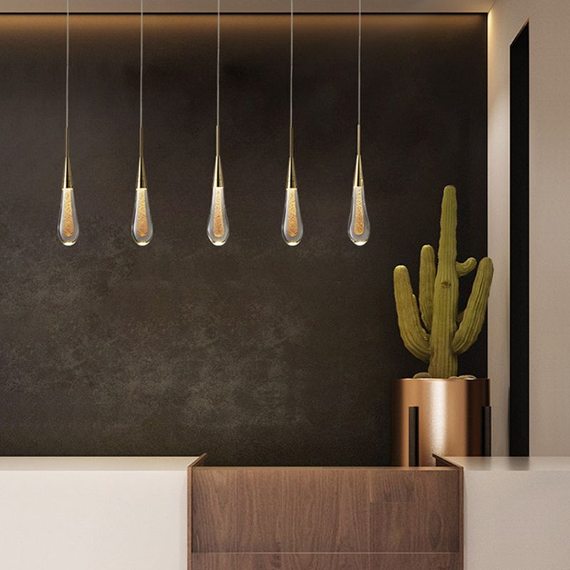 Five Clérachic Gold-Flecked Glass Teardrop Pendant Lights in an even row above a walnut counter against a dark plaster wall.