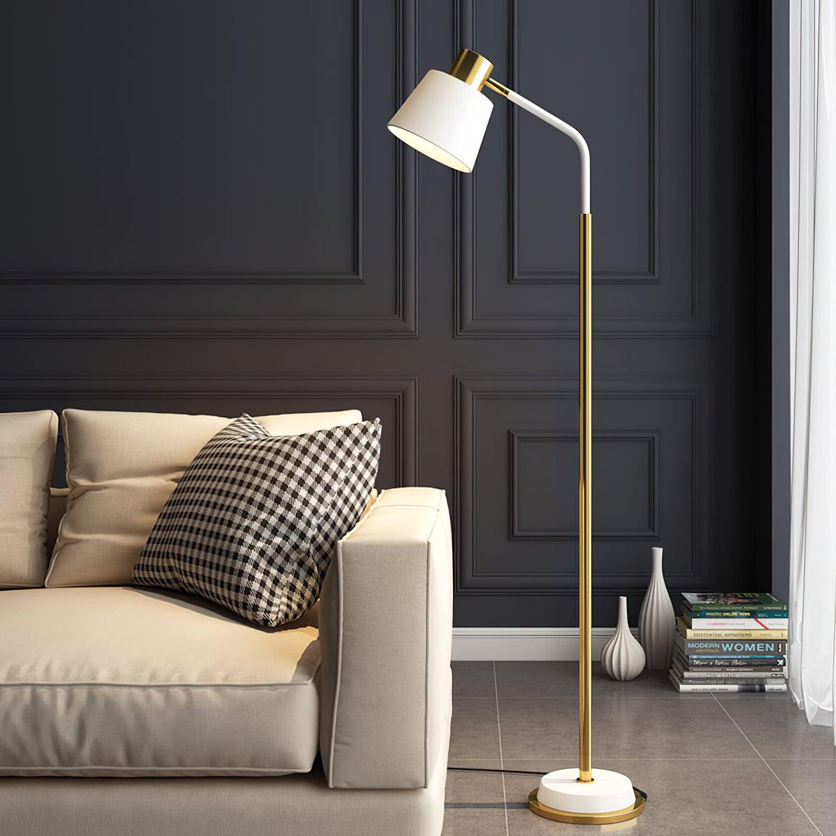 A Clérachic floor lamp with a white shade and gold stem beside a cream leather sofa, against a charcoal panelled wall.