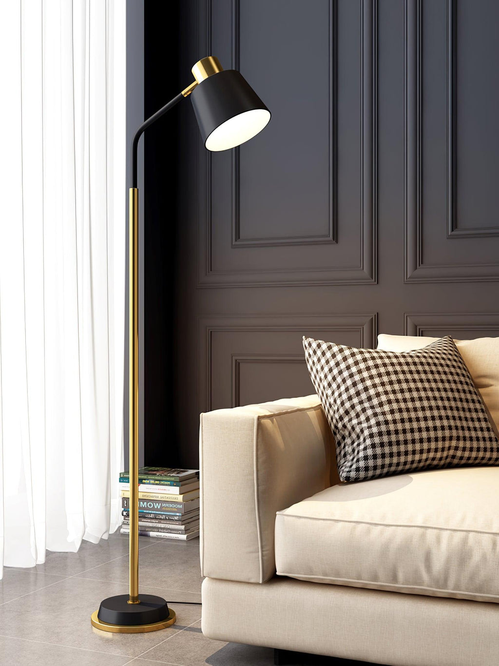 Lit Clérachic floor lamp with a black shade and gold stem, curving over a cream sofa with a checked cushion.