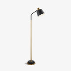 Clérachic floor lamp shown whole on a white backdrop, with a black shade, gold stem and black base with a gold rim.