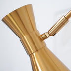 Close view of the hourglass-shaped gold cone shade on this Clérachic floor lamp and its small hinge to the arm.