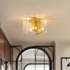 Lit Clérachic ceiling light with clear and amber glass panes in a hallway, with dark cabinets and a black-framed arched glass door behind.